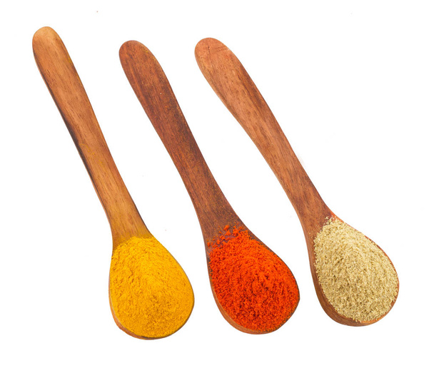Especias indias en cucharas de madera también se conocen como polvo de chile rojo, polvo de cúrcuma, polvo de cilantro, Mirchi, Mirch, Haldi, polvo de Dhaniya aislado sobre fondo blanco - Foto, Imagen