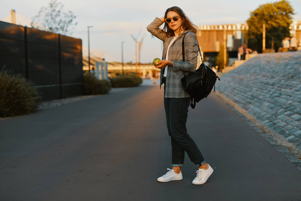 Mode Mädchen zu Fuß auf der Straße mit Sonnenuntergang Hintergrund - Foto, Bild