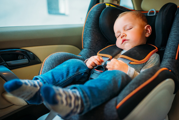 милый маленький ребенок спит в детском кресле безопасности в машине
 - Фото, изображение