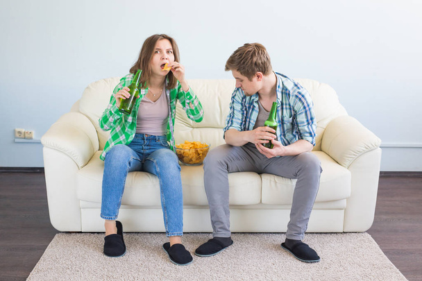 Couple of friends sitting in sofa watching sport game on tv - Photo, Image