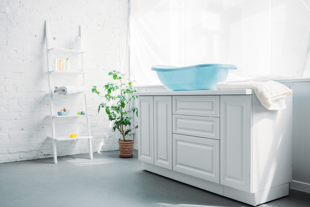 синій дитячі пластикові ванною на стенді в білий сучасний номер - Фото, зображення