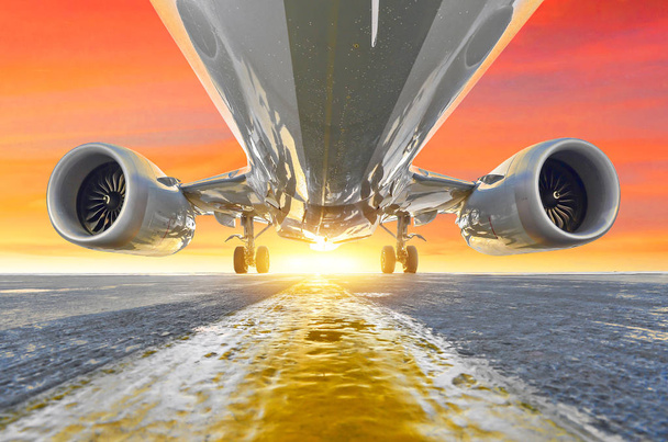 Літак на парковці перону аеропорту, др двигунів, фюзеляжу та крил. На тлі неба захід сонця червоні рожеві небо хмари
 - Фото, зображення