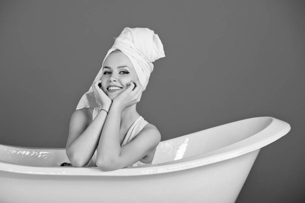 womens leisure. happy sexy woman with towel turban sitting in white bathtub - Foto, afbeelding
