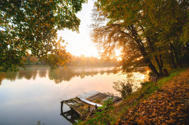 Herfst gebladerte lake in ochtend met pier - Foto, afbeelding