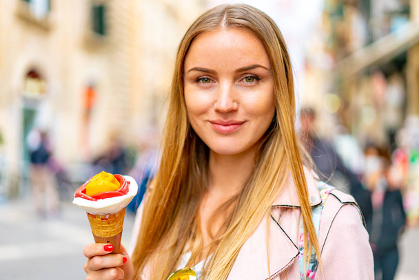 Outdoor closeup fashion portrait of young sexy girl eating ice cream in summer hot weather have fun and good mood. Toned style instagram filters. - Foto, imagen