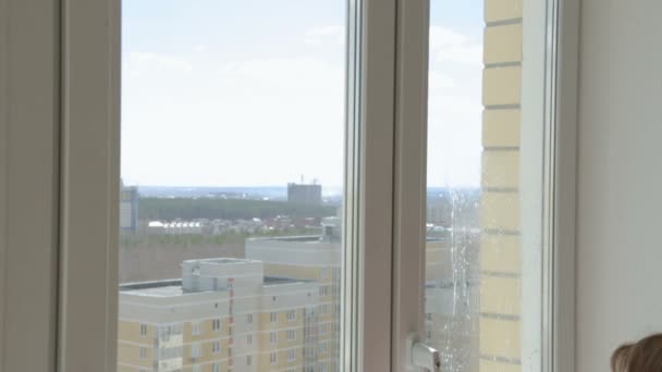 Nainen puhdistaa kodin ikkunat korkeassa kerroksessa
 - Materiaali, video