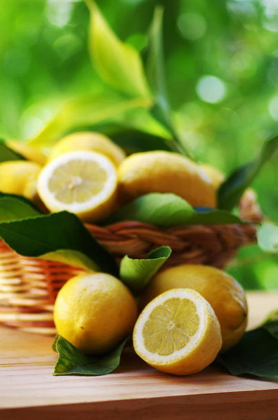 Fresh ripe lemons in basket on table - Zdjęcie, obraz