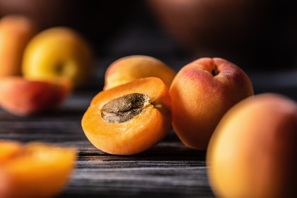 selective focus of ripe apricots on wooden table - Fotoğraf, Görsel