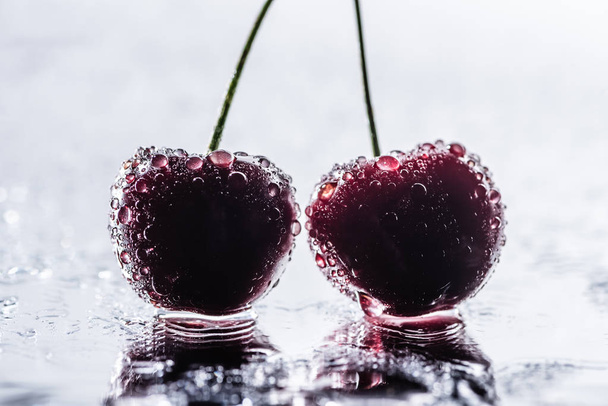 selective focus of red ripe cherries with water drops on wet surface  - Fotografie, Obrázek
