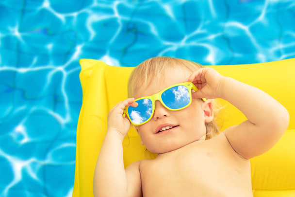 Funny baby boy on summer vacation. Child having fun in swimming pool - Фото, зображення