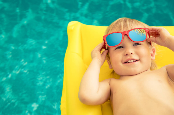 Funny baby boy on summer vacation. Child having fun in swimming pool - Fotografie, Obrázek