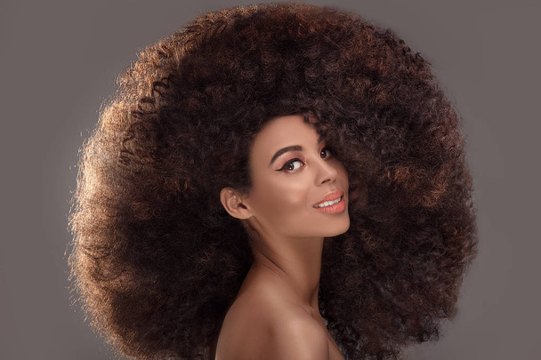Beauty portrait of attractive african american woman with long afro hairstyle and glamour makeup, studio shot. - Фото, изображение