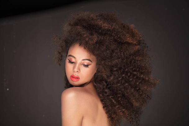 Beauty portrait of attractive african american woman with long afro hairstyle and glamour makeup, studio shot. - Foto, Imagen