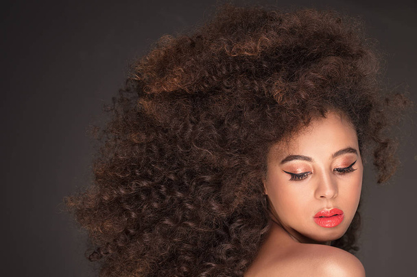 Retrato de belleza de la atractiva mujer afroamericana con peinado afro largo y maquillaje glamour, toma de estudio
. - Foto, imagen