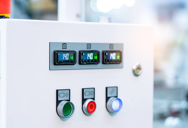 Θερμοκρασία ελέγχου πίνακα Υπουργικού περιέχουν ψηφιακή οθόνη για μετρητή θερμοκρασίας. πράσινο, κόκκινο και λευκό κουμπί για άνοιγμα, κλείσιμο, και ρυθμίστε το μηχάνημα. Έλεγχο θερμότητας σε βιομηχανικό εργοστάσιο.  - Φωτογραφία, εικόνα