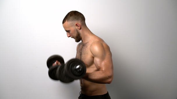 Shirtless muscular man training with dumbbell - Footage, Video