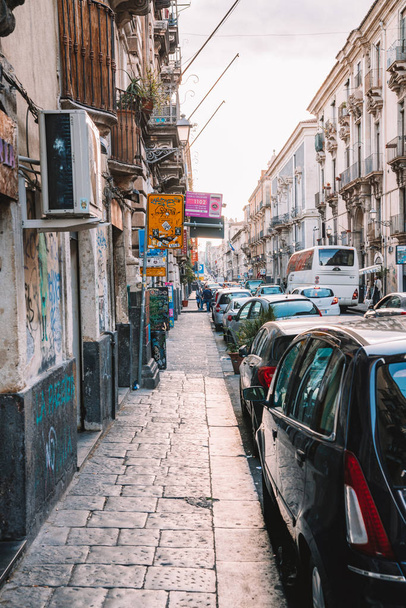 May 10, 2018. Catania, Italy. Narrow cosy streets of Catania with small buildings, and different restaurants.  - Fotó, kép