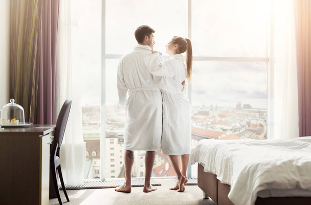 Joven pareja amorosa en la habitación de hotel por la mañana
 - Foto, Imagen