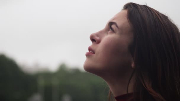 Close-up face of young sensual woman looking up at rain - Footage, Video