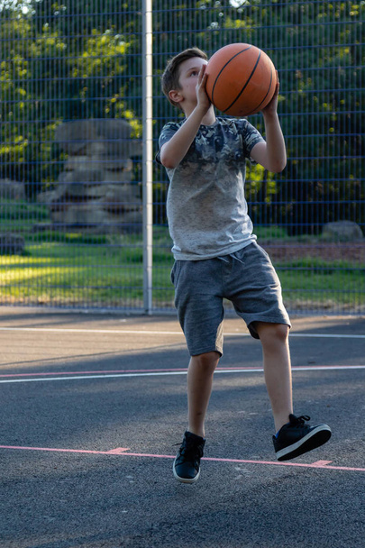 Pre-teen boy playing with a basketball in a park - Foto, Imagem