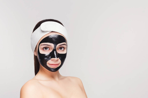 Jovem com purificação máscara facial preta
 - Foto, Imagem
