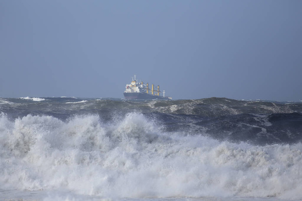 Kereskedelmi hajót vihar a tengeren, a nagy hullámok, de egy gyönyörű kék ég alatt - Fotó, kép