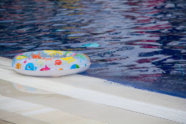 Anello galleggiante sulla piscina blu con onde
 - Foto, immagini