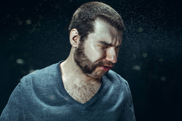 Young handsome man with beard sneezing, studio portrait - Foto, Imagem