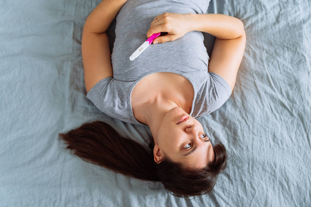 szomorú asszony-ágyon negatív terhességi teszt - Fotó, kép