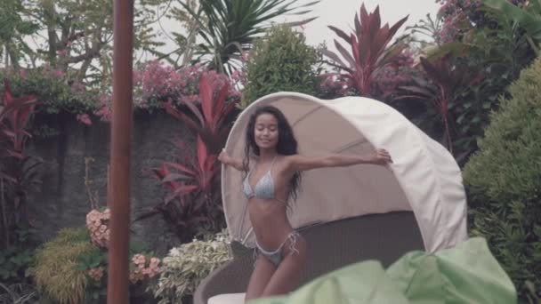 Mooie sexy dame in bikini relaxen aan het zwembad. Portret van fashion model meisje buitenshuis. Schoonheid vrouw met aantrekkelijk lichaam in zwembroek - Video