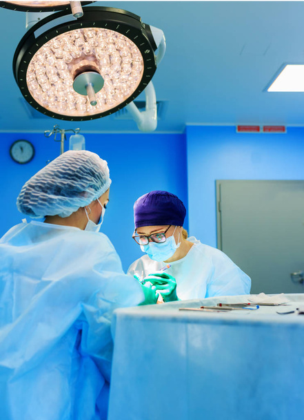 Surgeons operating a patient in operating room - Photo, Image