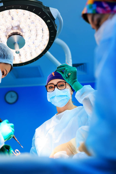 Surgeons operating a patient in operating room - Photo, Image