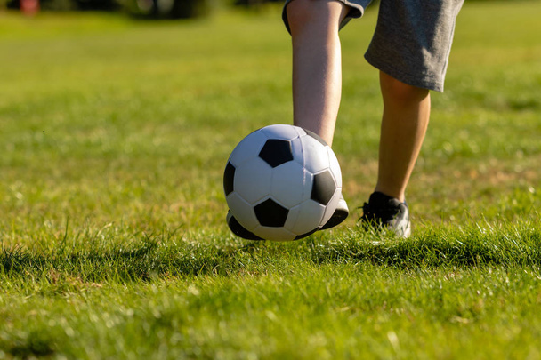 Ragazzo pre-adolescente che gioca con un calcio in un parco
 - Foto, immagini