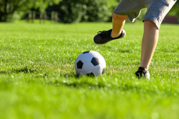 Pre-teen boy playing with a football in a park - Foto, Bild
