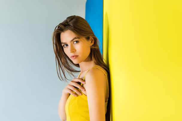 Female fashion model in yellow clothes on blue and yellow background - Photo, Image