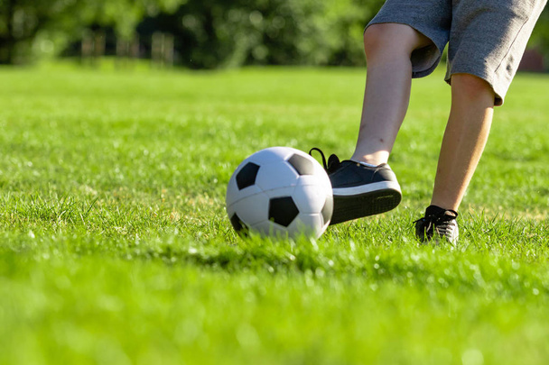 Pre-teen boy playing with a football in a park - Foto, Imagem