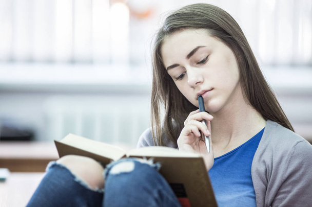 Diák lány elolvassa a könyvet, a szobában - Fotó, kép