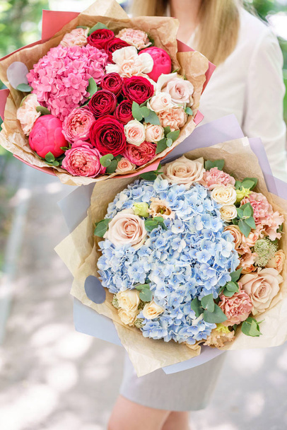 Two Beautiful summer bouquet. Arrangement with mix flowers. Young girl holding a flower arrangement with hydrangea. The concept of a flower shop. Content for the catalog - Photo, Image
