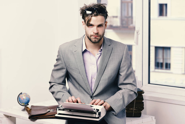 Man with serious face types story or business report. - 写真・画像