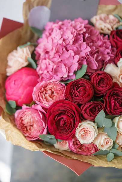 schöner Frühlingsstrauß. Blumenschmuck mit Hortensien und Pfingstrosen. Farbe rot und rosa. Konzept eines Blumenladens, eines kleinen Familienunternehmens - Foto, Bild