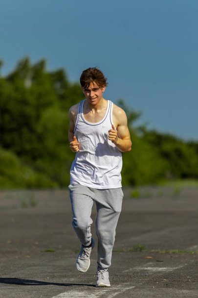 Young male caucasian adult jogging outside on a warm summer's day - Foto, immagini