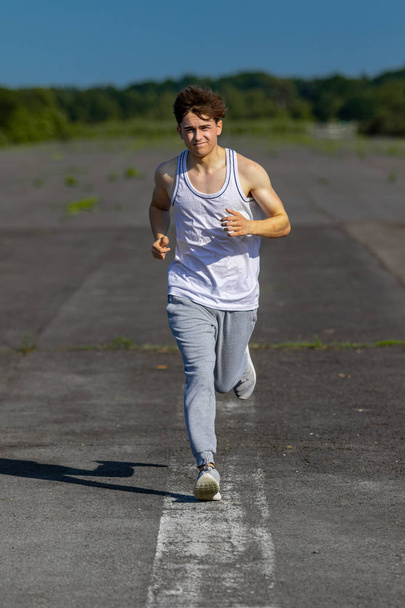 Jovem homem caucasiano adulto jogging fora em um dia quente de verão
 - Foto, Imagem