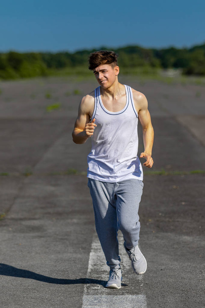 Young male caucasian adult jogging outside on a warm summer's day - Photo, image