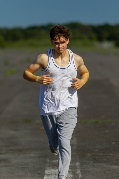 Young male caucasian adult jogging outside on a warm summer's day - Φωτογραφία, εικόνα