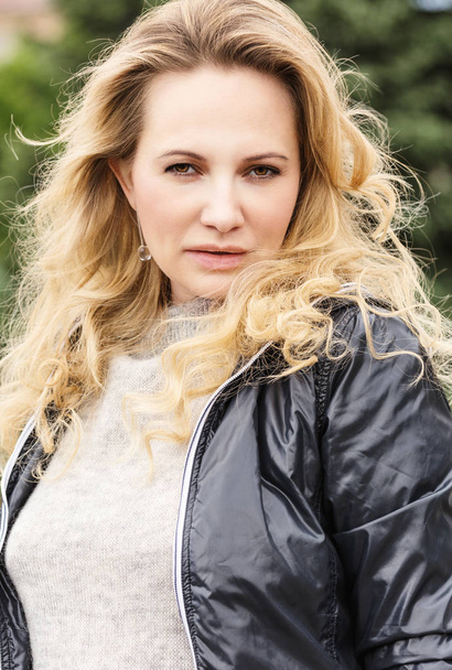 Beautiful blonde woman with long hair in jacket, close-up - Fotó, kép