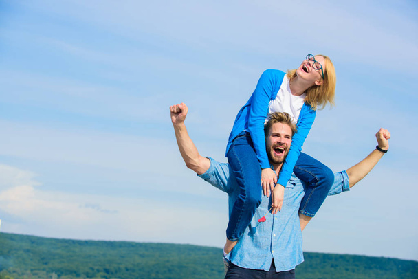 Soulmates enjoy freedom together. Man carries girlfriend on shoulders, sky background. Couple happy date having fun together. Freedom concept. Couple in love enjoy freedom outdoor sunny day - 写真・画像