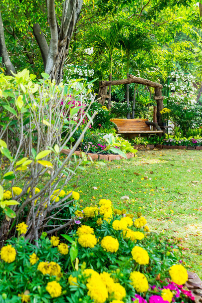 Καρέκλα ξύλο στο άνετο σπίτι λουλούδια κήπος το καλοκαίρι. - Φωτογραφία, εικόνα