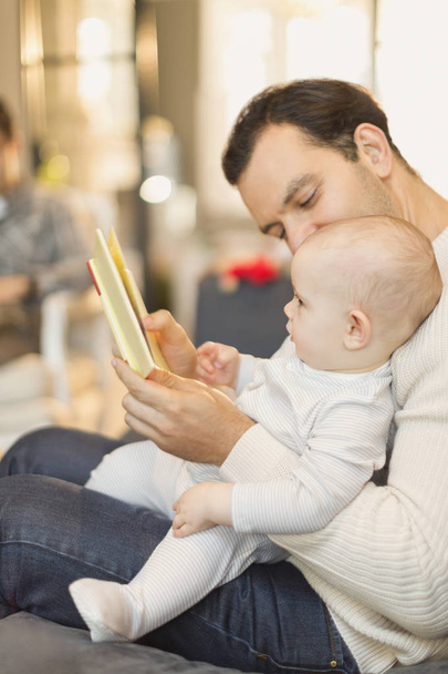 Ojciec czytanie książki do cute baby syn - Zdjęcie, obraz