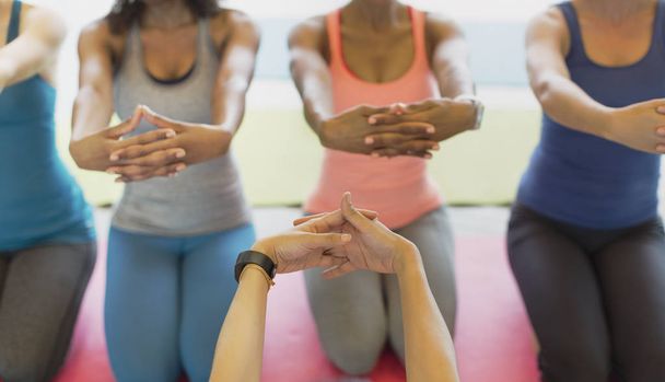 Perspectiva personal instructor de fitness y las mujeres que estiran los brazos en clase de ejercicio
 - Foto, Imagen