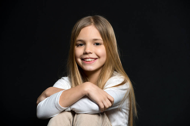 Cuteness overload. Girl long hair cute smiling face relaxing, black background. Smile of this girl amazes with cuteness. Be nice to people. Happiness of little kid filling you positive energy - Fotoğraf, Görsel